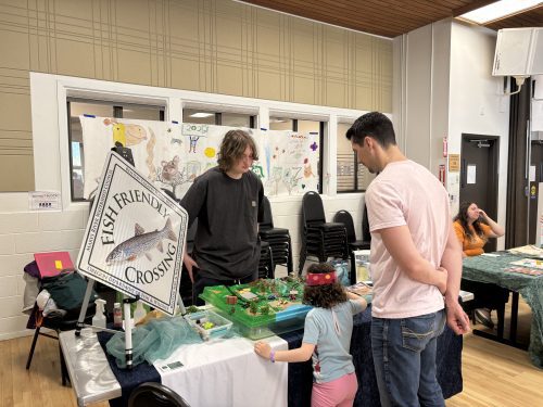 Photo of a Youth Watershed Council member leading a tabling activity.